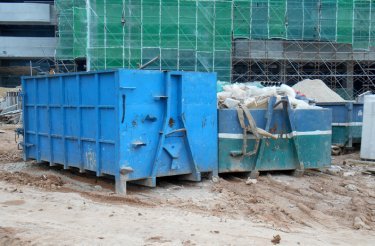 blå-containere-på-jorden-på-byggeplads