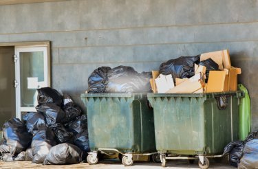 Grüne Abfallcontainer mit Müll im Back-of-House-Bereich