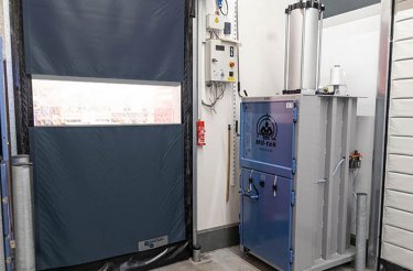 Pneumatische Ballenpresse A305 neben einer Hintertür platziert