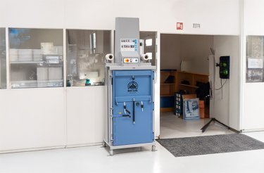 Blaue Ballenpresse an einer Wand neben einer Türöffnung