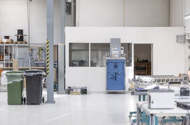 Blaue Ballenpresse an einer Wand in Produktionsumgebung